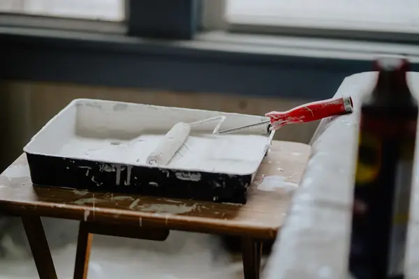 Paint roller and tray of white paint ready for a job